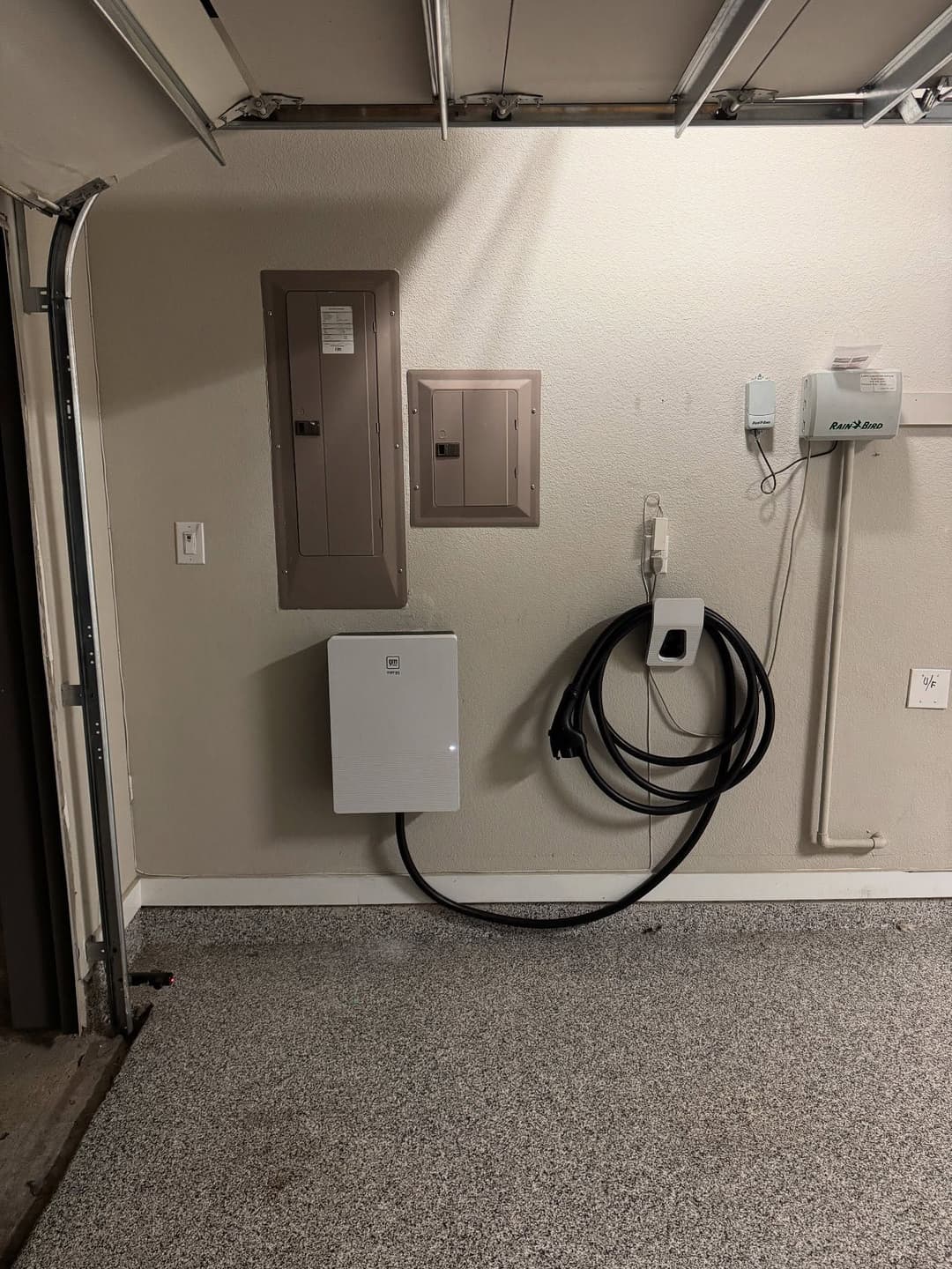 Home garage with electrical panel and EV charger station installed on the wall.