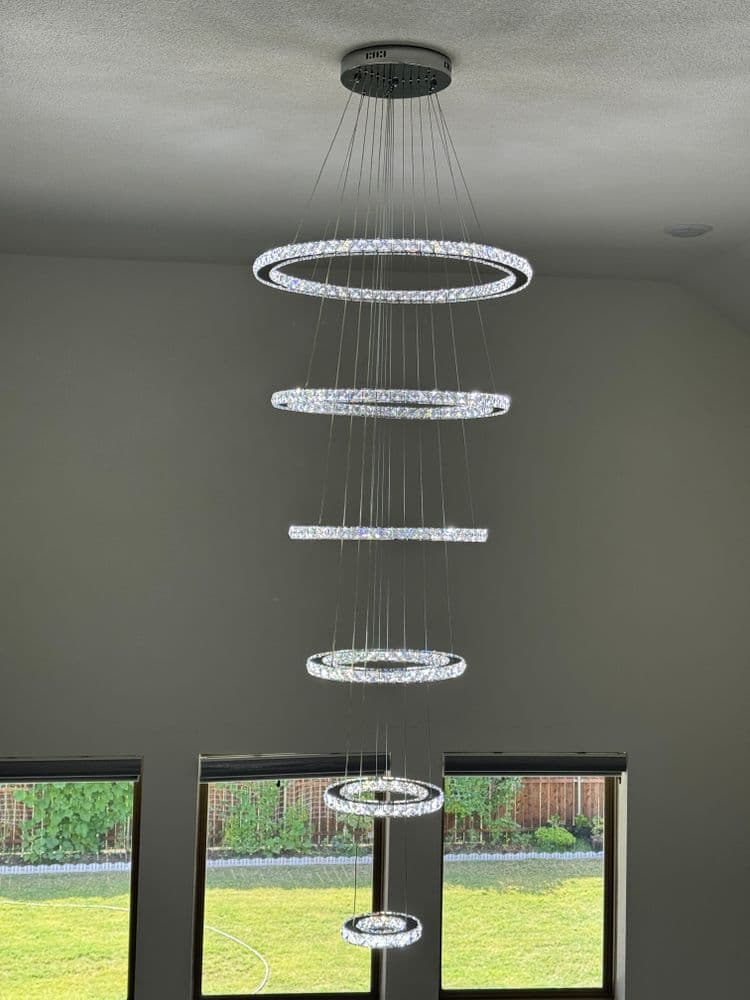 Contemporary circular LED chandelier hanging from the ceiling in a modern room.