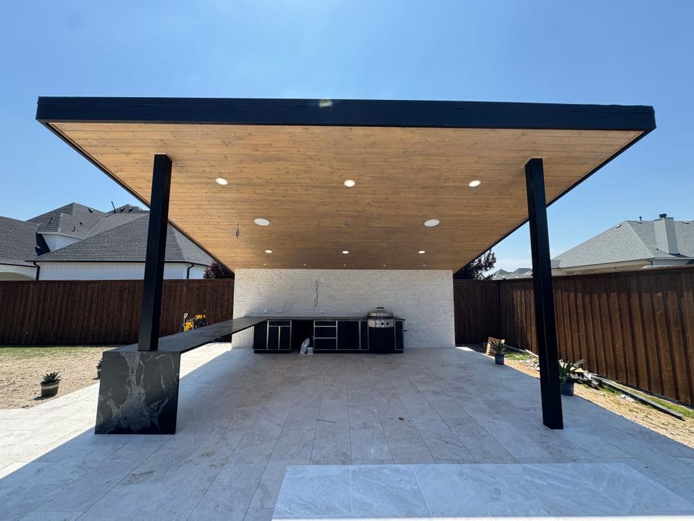 Modern outdoor kitchen pavilion with sleek black accents and polished stone flooring.